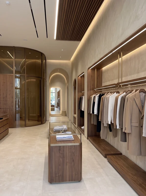 A dressing space with illuminated cabinetry, timber detailing and a central island.