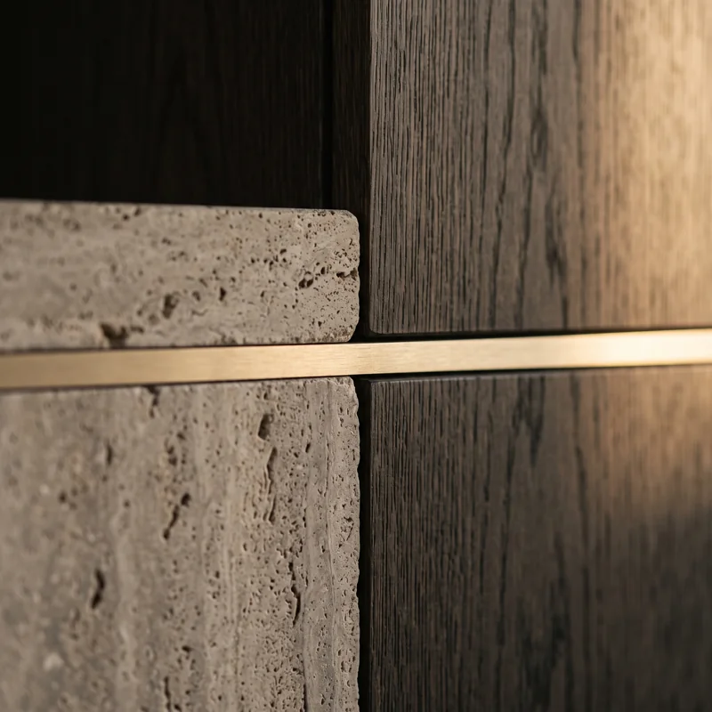 A close view of textured stone, dark timber and a fine metallic inlay.